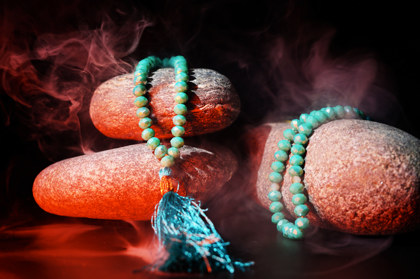 Resin prayer beads styled on river stones with mist