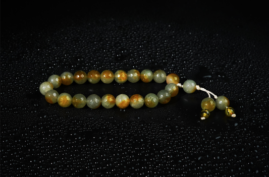 Olive agate tasbih on dark textured backdrop