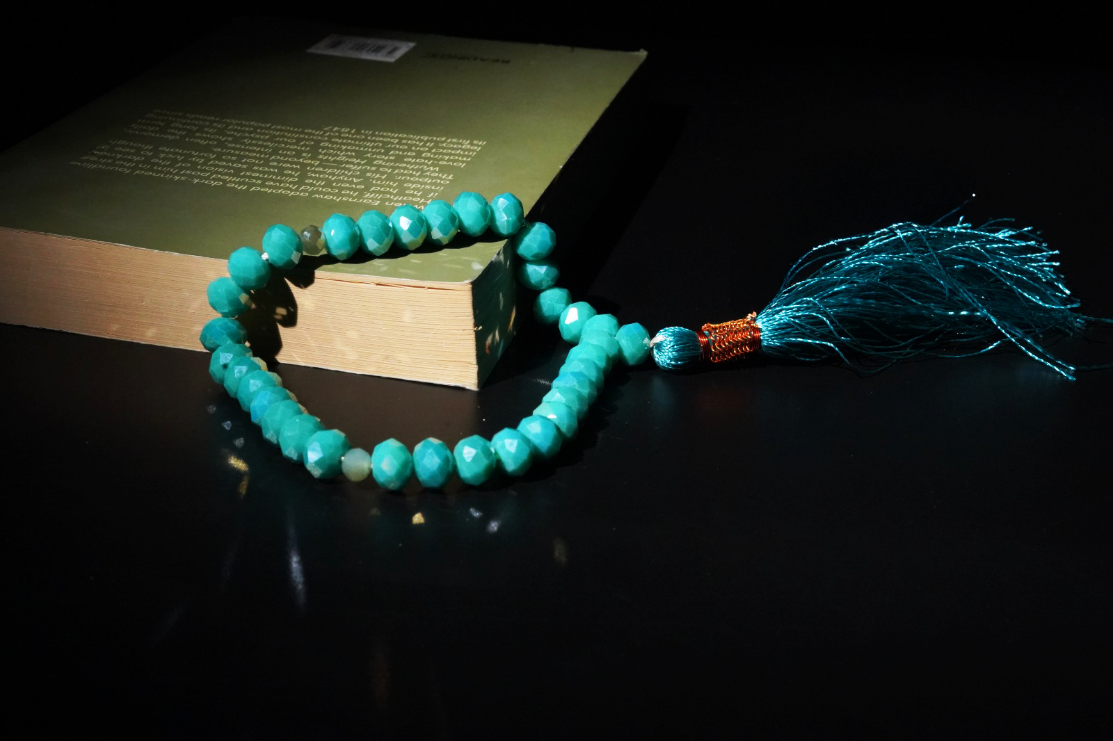 Resin prayer beads styled in a cozy environment with a book