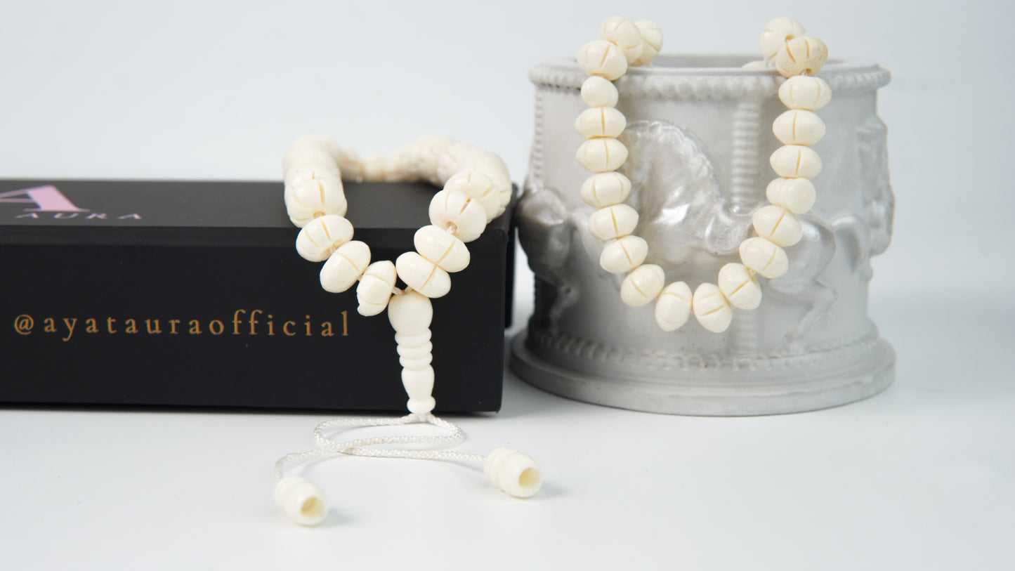 Close-up of carved bone beads and ivory cord