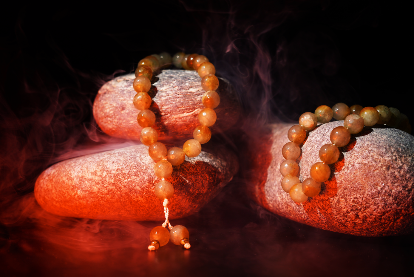 Olive/gold agate prayer beads styled on stones with mist