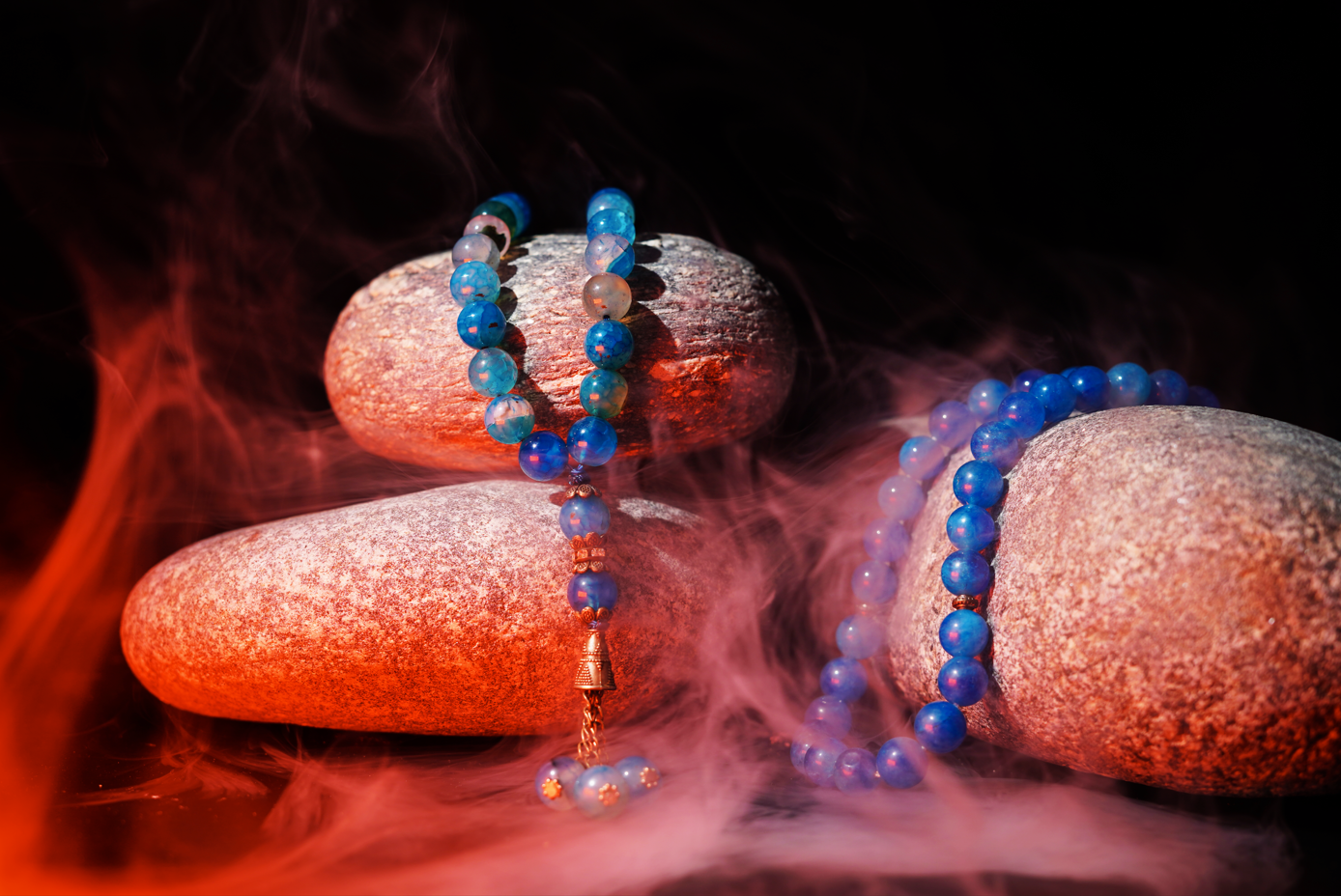 Blue agate prayer beads styled on stones with mist