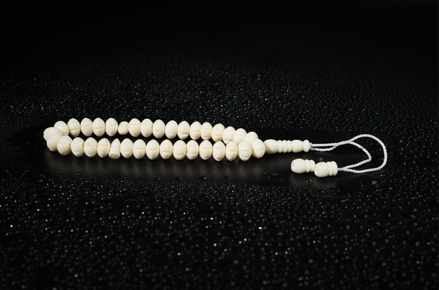 Camel bone tasbih on dark textured backdrop