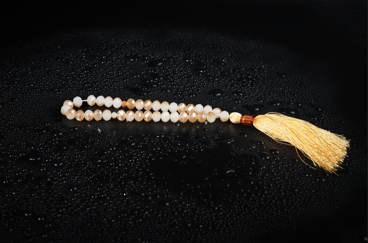 Sand-gold resin tasbih on dark textured backdrop